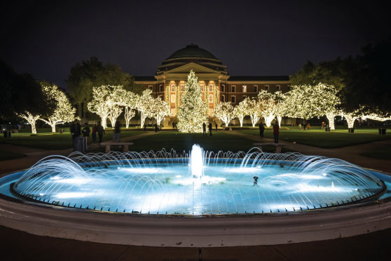 SMU students and young alumni posing together under holiday lights at Celebration of Lights