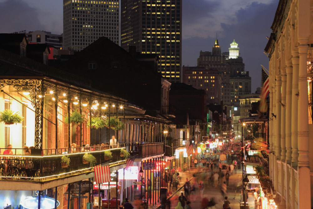 Bourbon Street balconies and neon lights in the French Quarter at night.