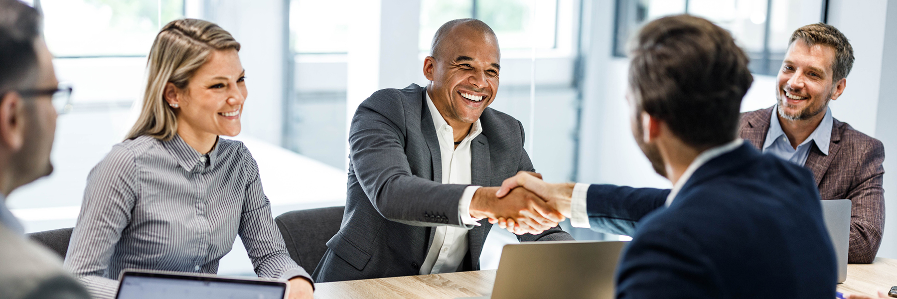 Happy business people shaking hands on a meeting in the office.