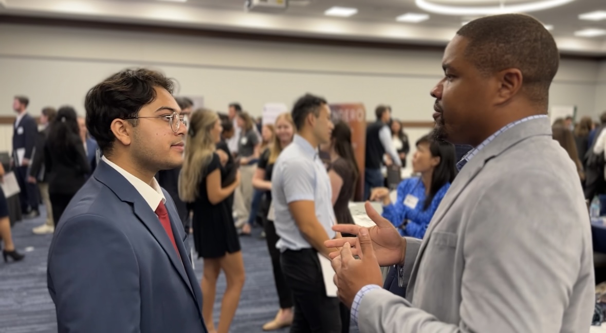 Student talks with employer at SMU Cox career fair