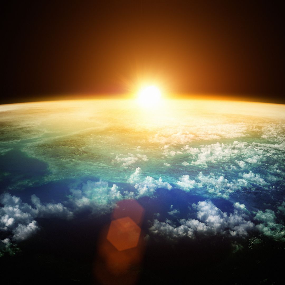 Photo of the sun coming up over earth's horizon