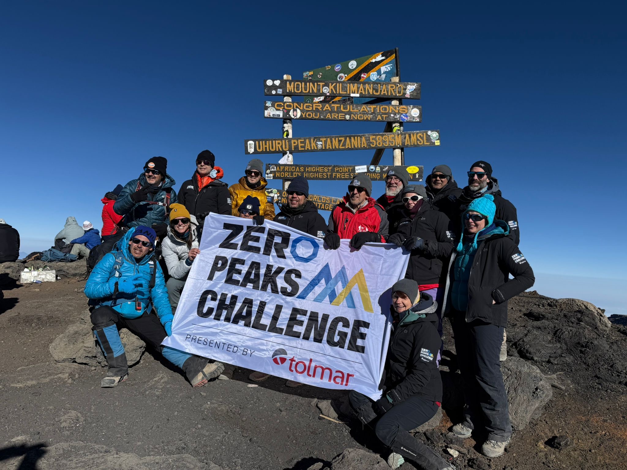Leskovskaya and the rest of her climbing group on Mount Kilimanjaro holding a Zero Peaks Challenge sign