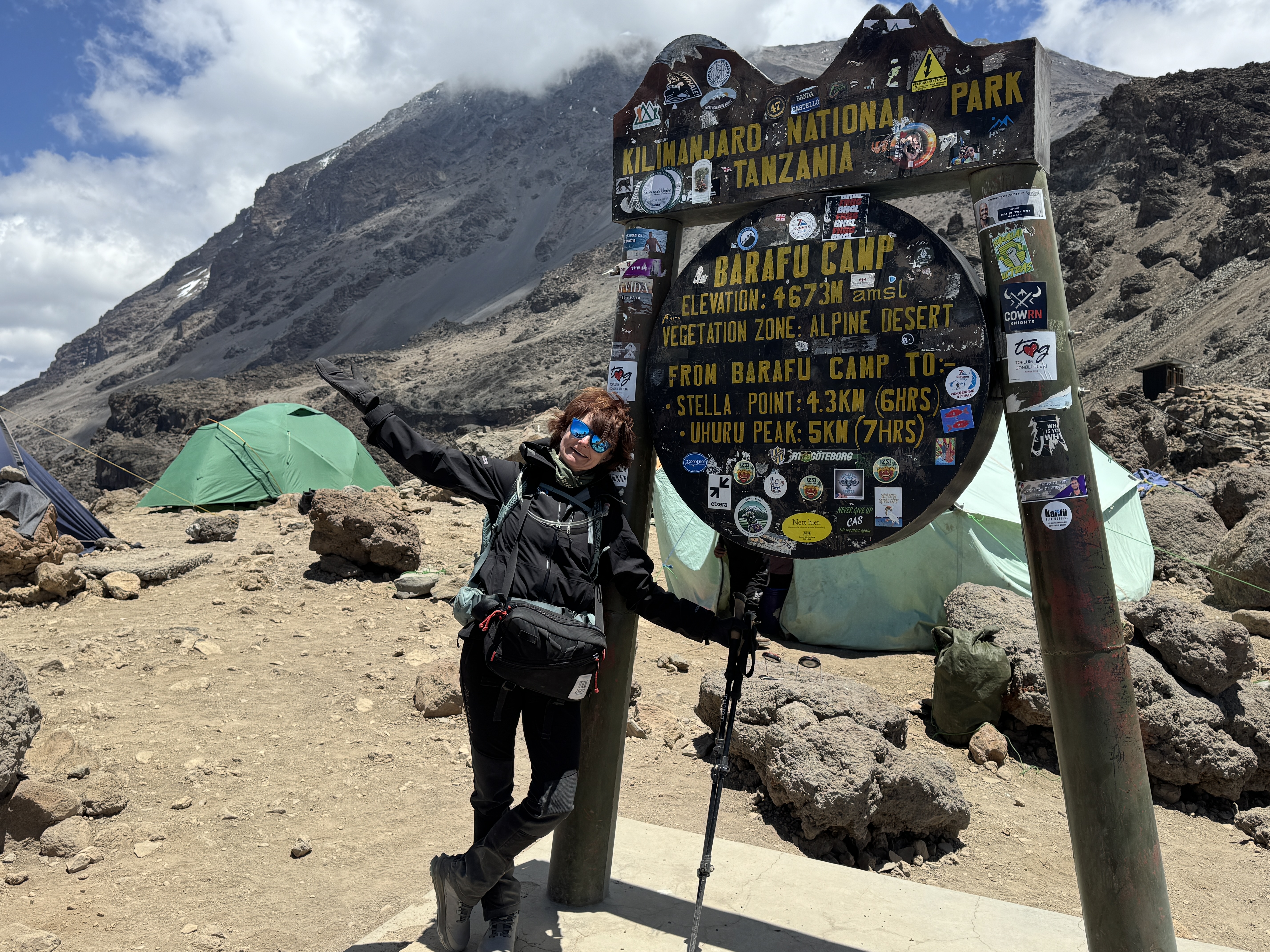 Angelika Leskovskaya poses in front of the sign for Barafu Camp on Mount Kilimajaro 