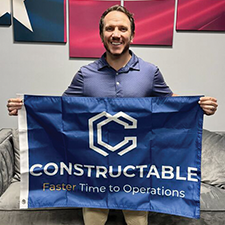 Ryan Banko holds up a flag that reads "Constructable"