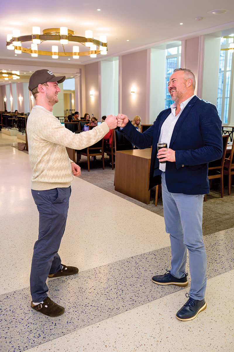 Dean Todd Milbourn fist-bumps an SMU Cox student 
