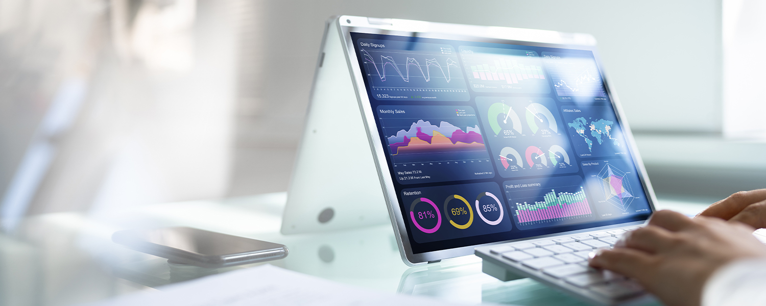 A woman typing at a tablet showing many different graphs and charts