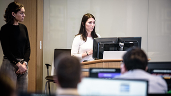 Students presenting in frontb of calass at Cox School