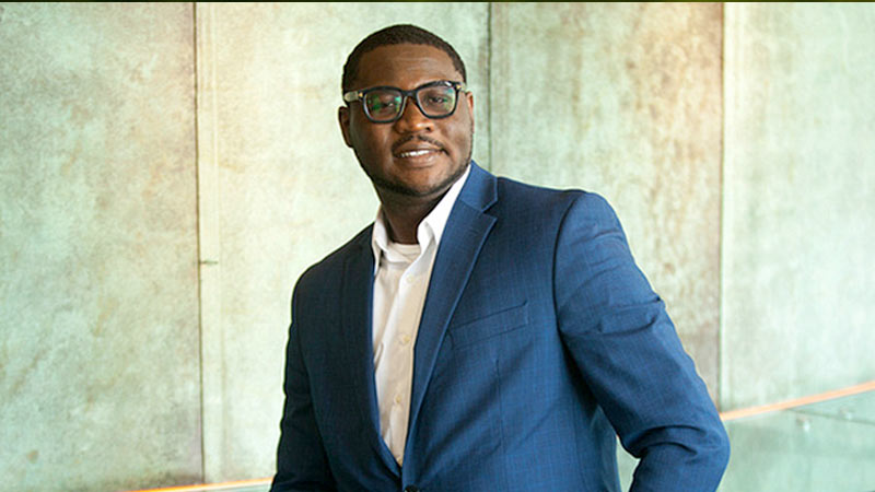 student standing against brick wall