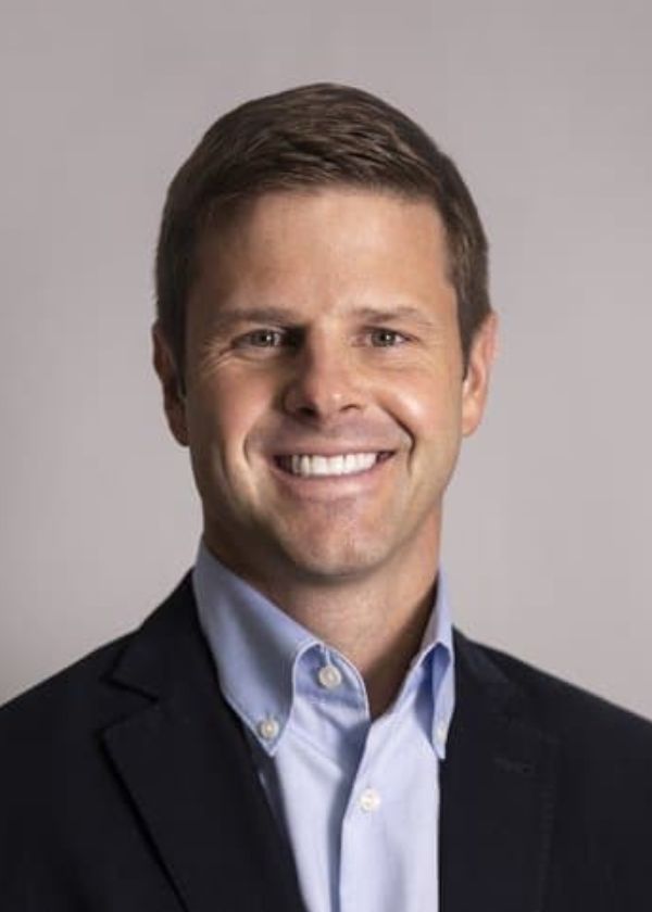 Professional headshot of Jay Dempsey in a blue shirt and black suit jacket