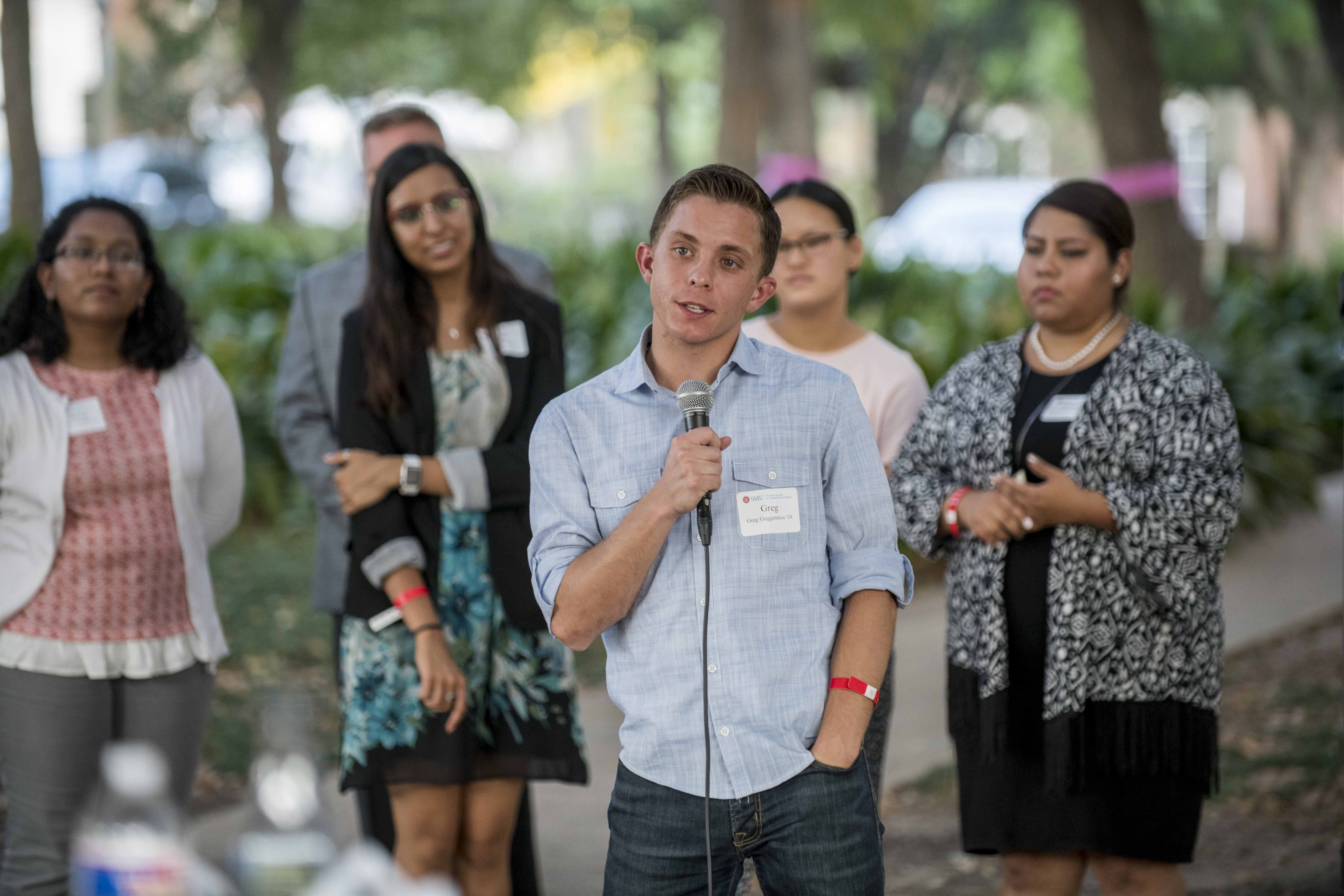 Student standing, speaking into microphone 