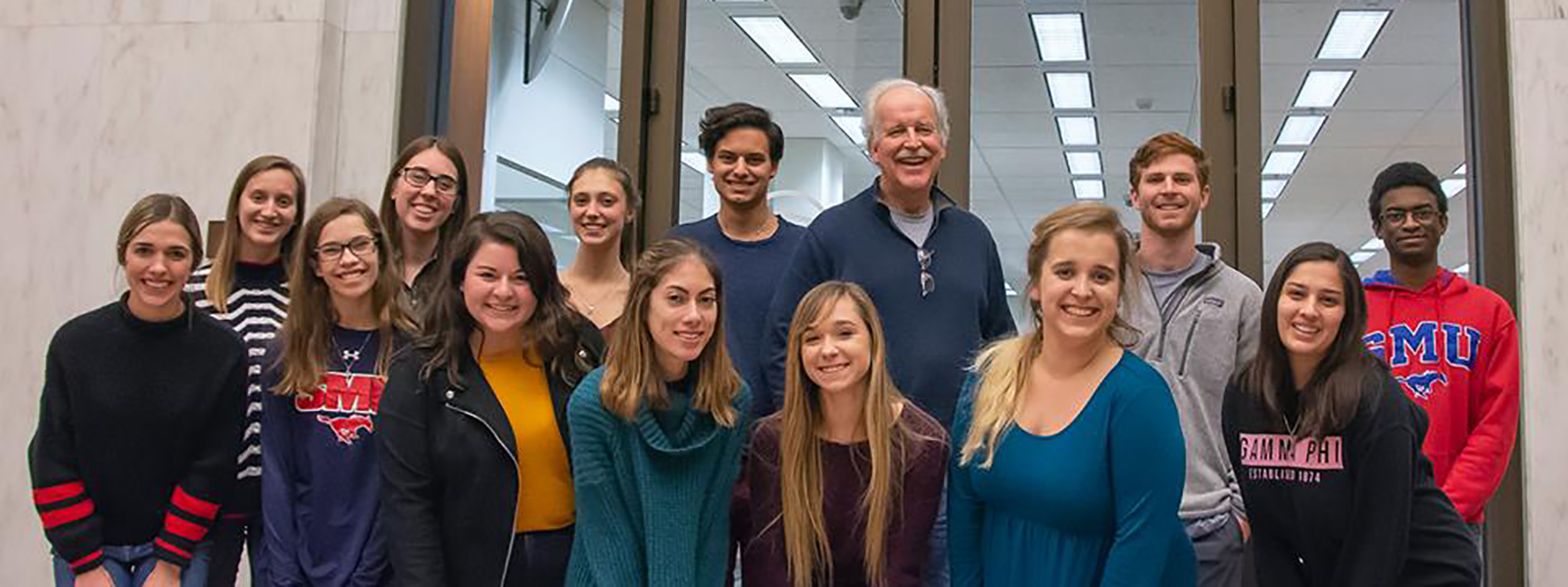 Group of people standing together smiling. 