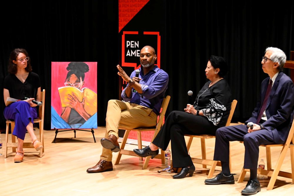 Panel of speakers seated on stage.