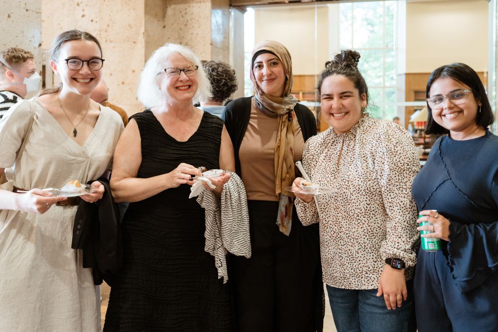 Five women pose and smile for a photo.