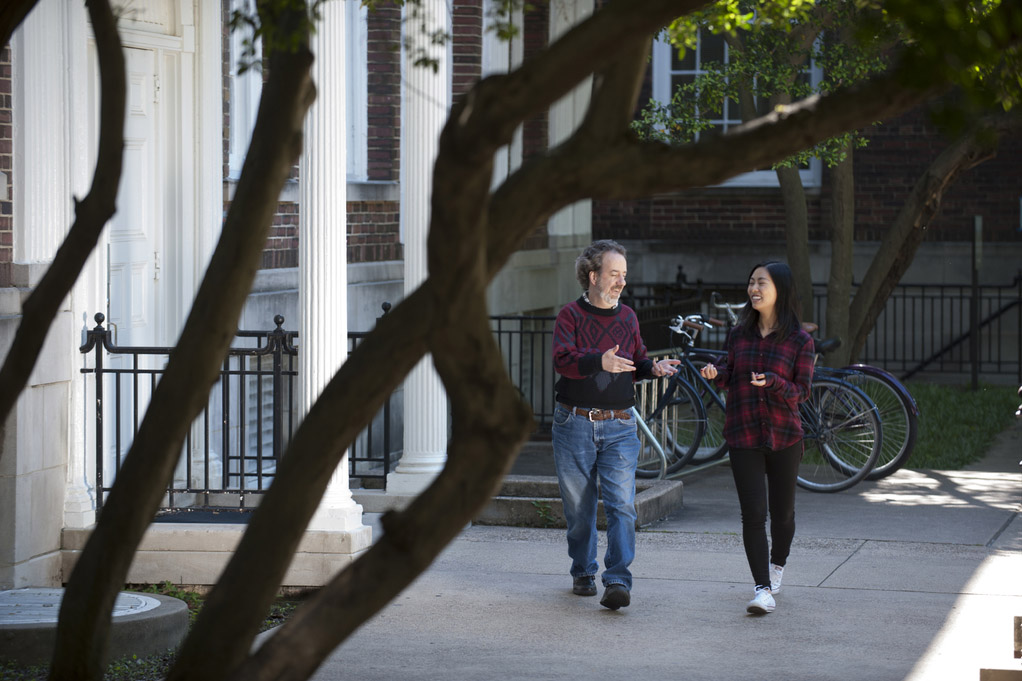 Student walking on campus with Bob Kehoe