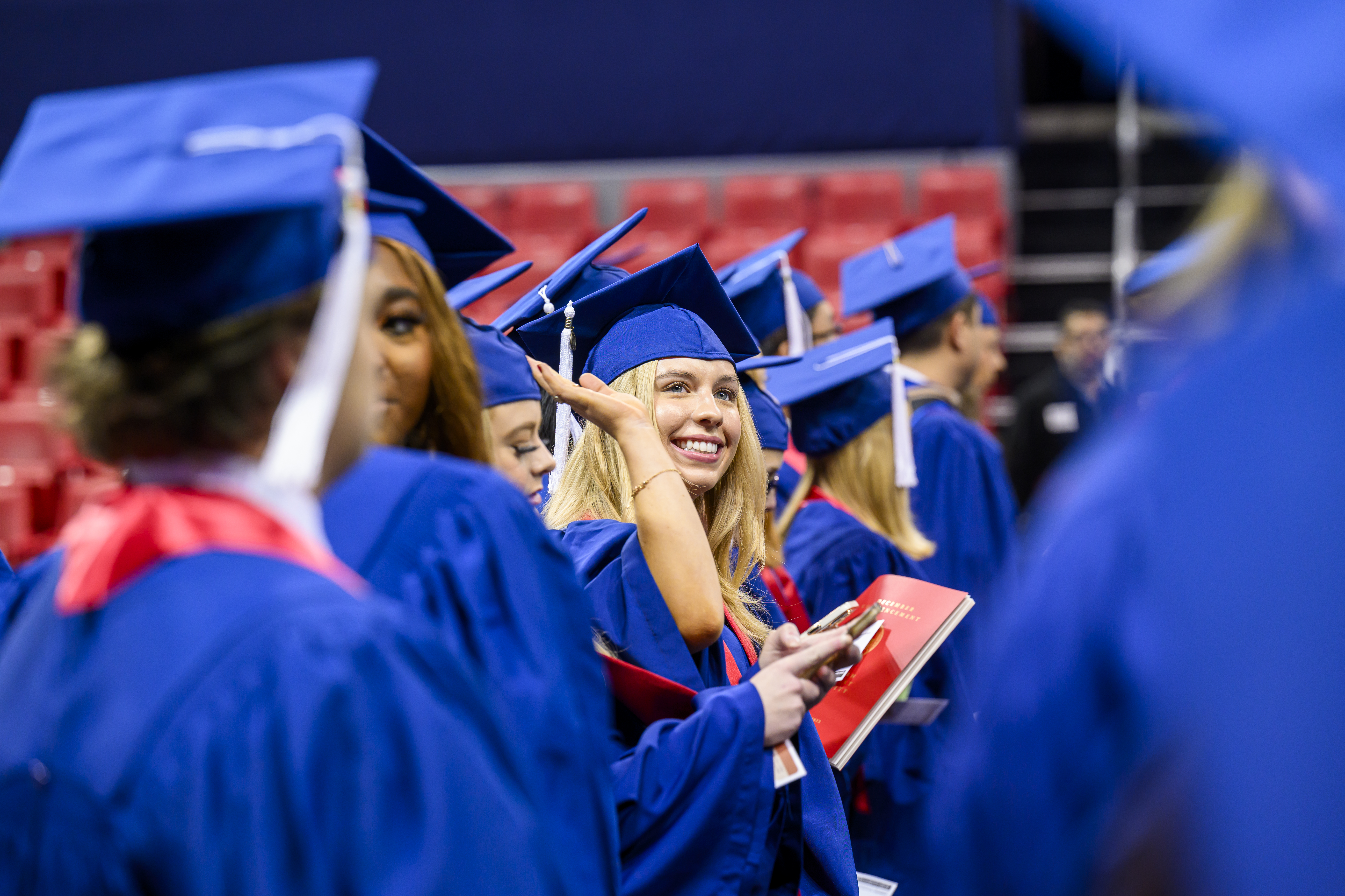 student waving at graduation
