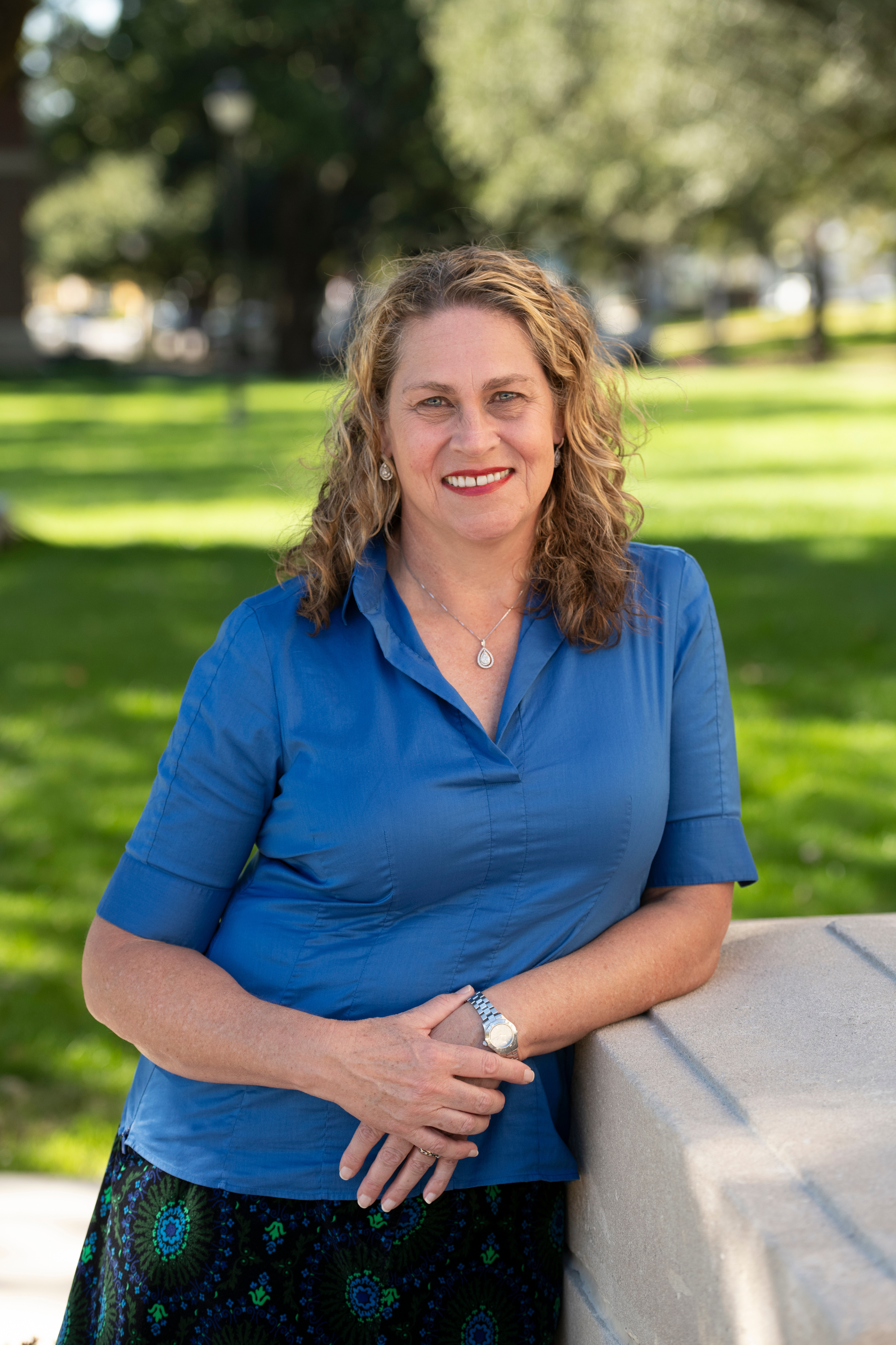 Photo of Eva Oberdoerster leaning on a ledge wearing a blue shirt