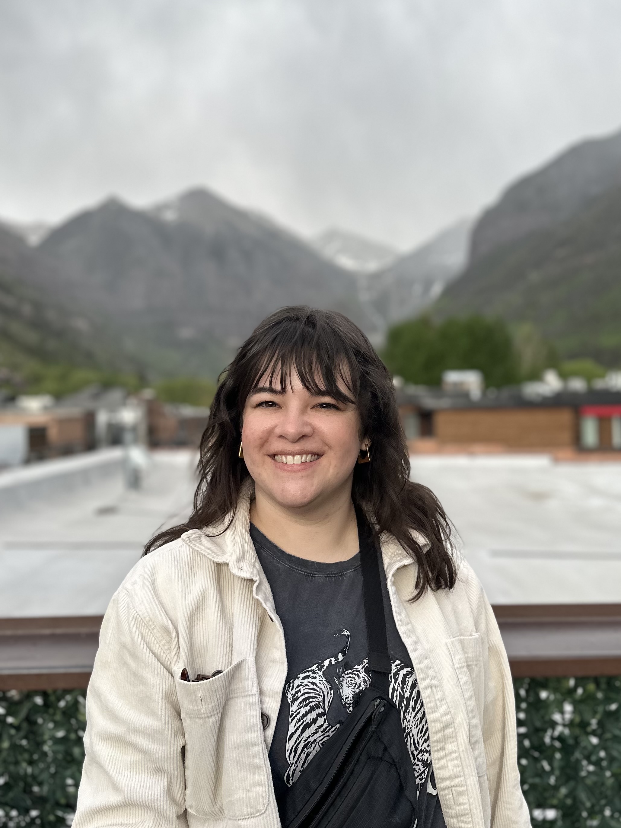 Headshot of Madi Thorpe with white jacket and gray t shirt