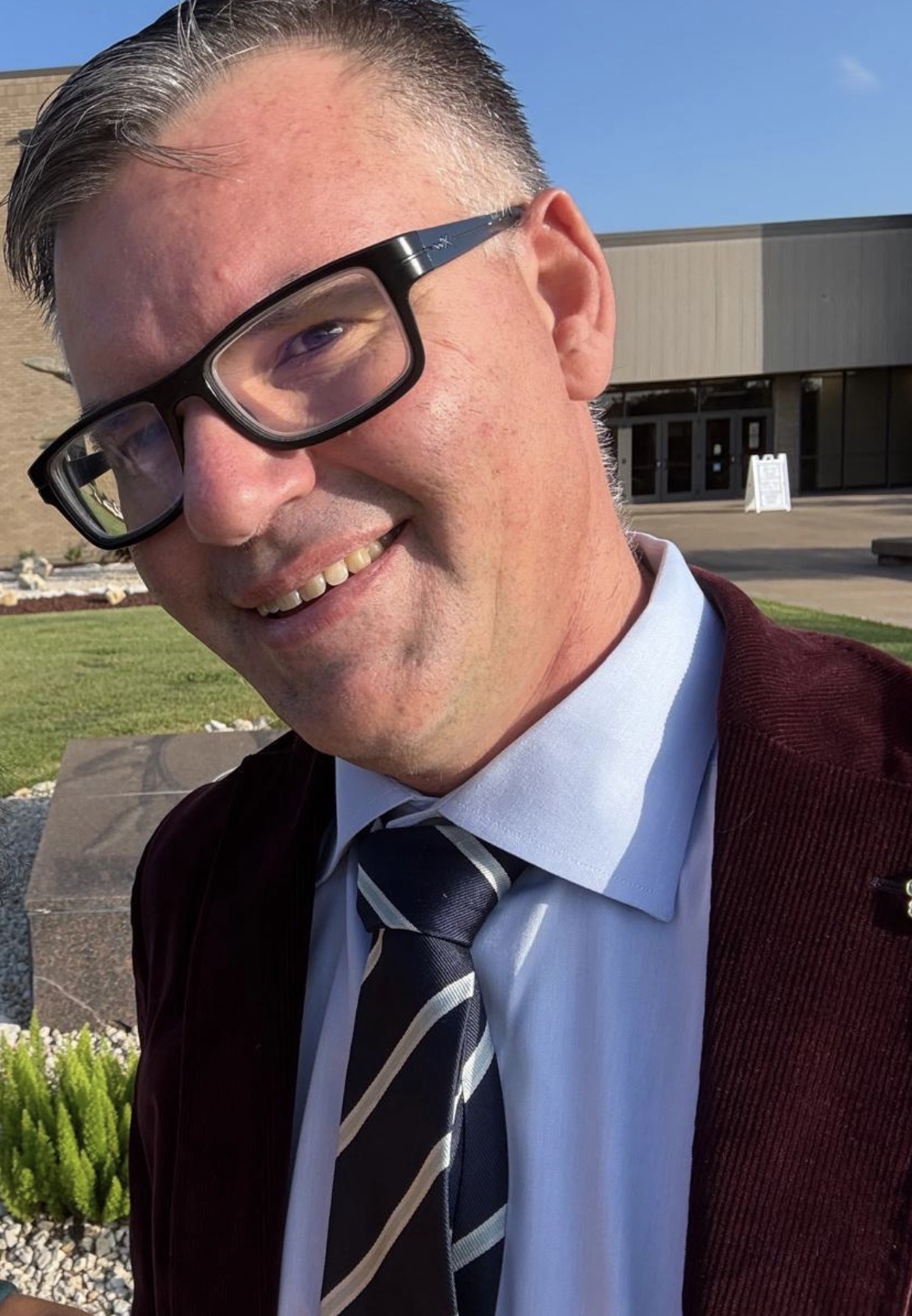 Man wearing glasses with suite and stripped tie