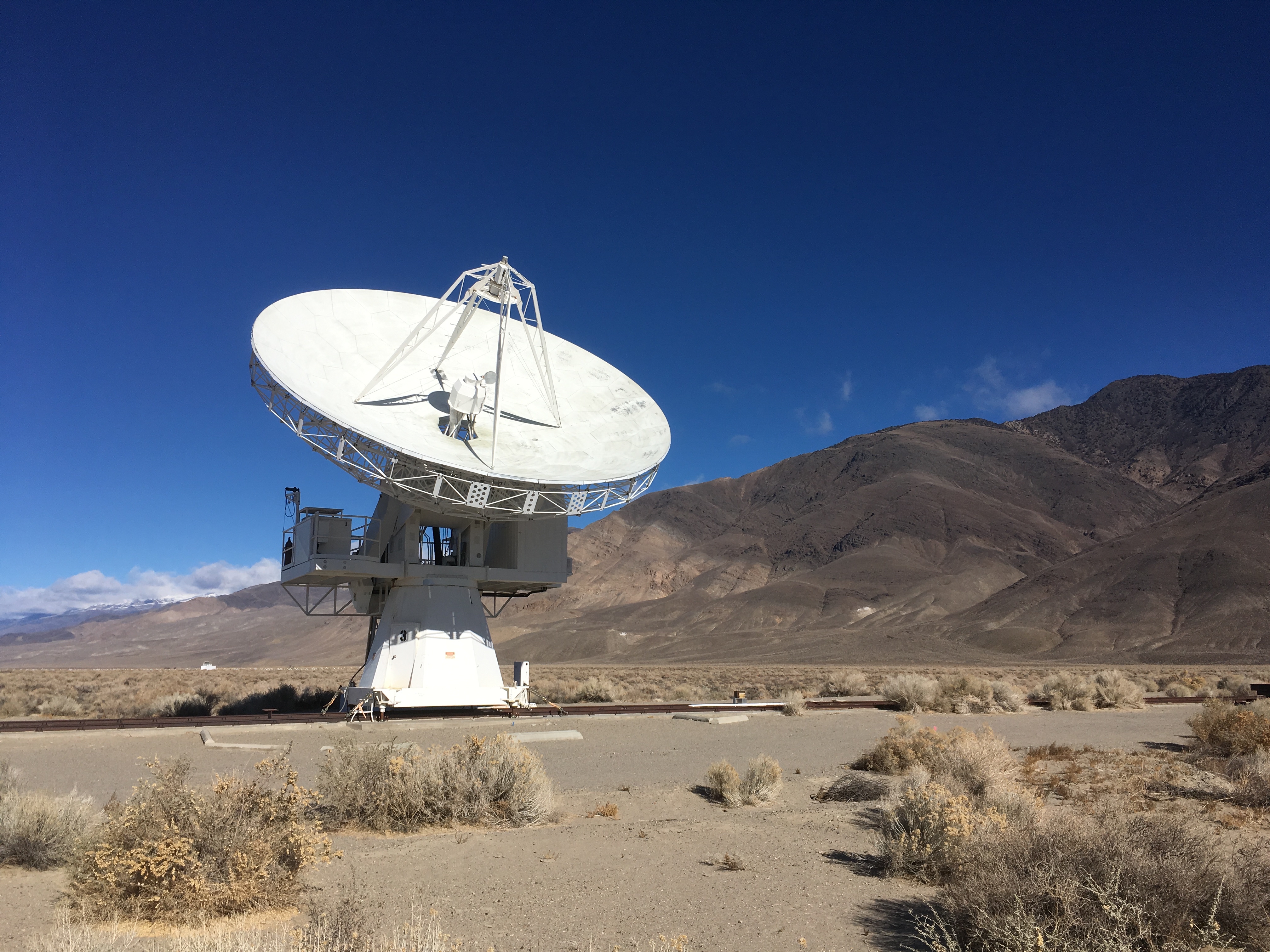 Large, white telescope, aimed at the sky in the desert