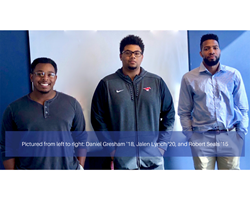 Vuzag founders, Daniel Gresham '18, Jalen Lynch '20, and Robert Seals '15, standing in front of a blue wall.