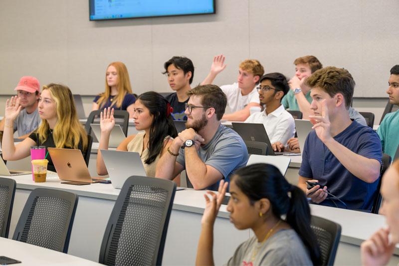 BBA Scholars - students in a classroom with raised hands