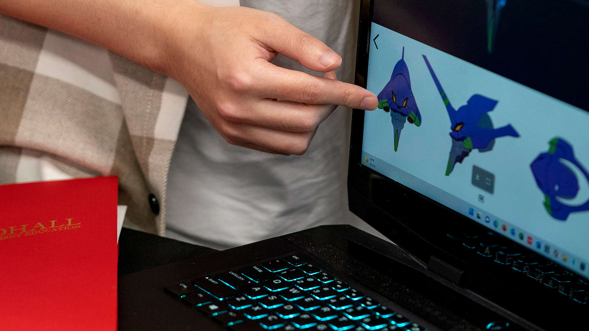 Photo of student pointing at portfolio on screen