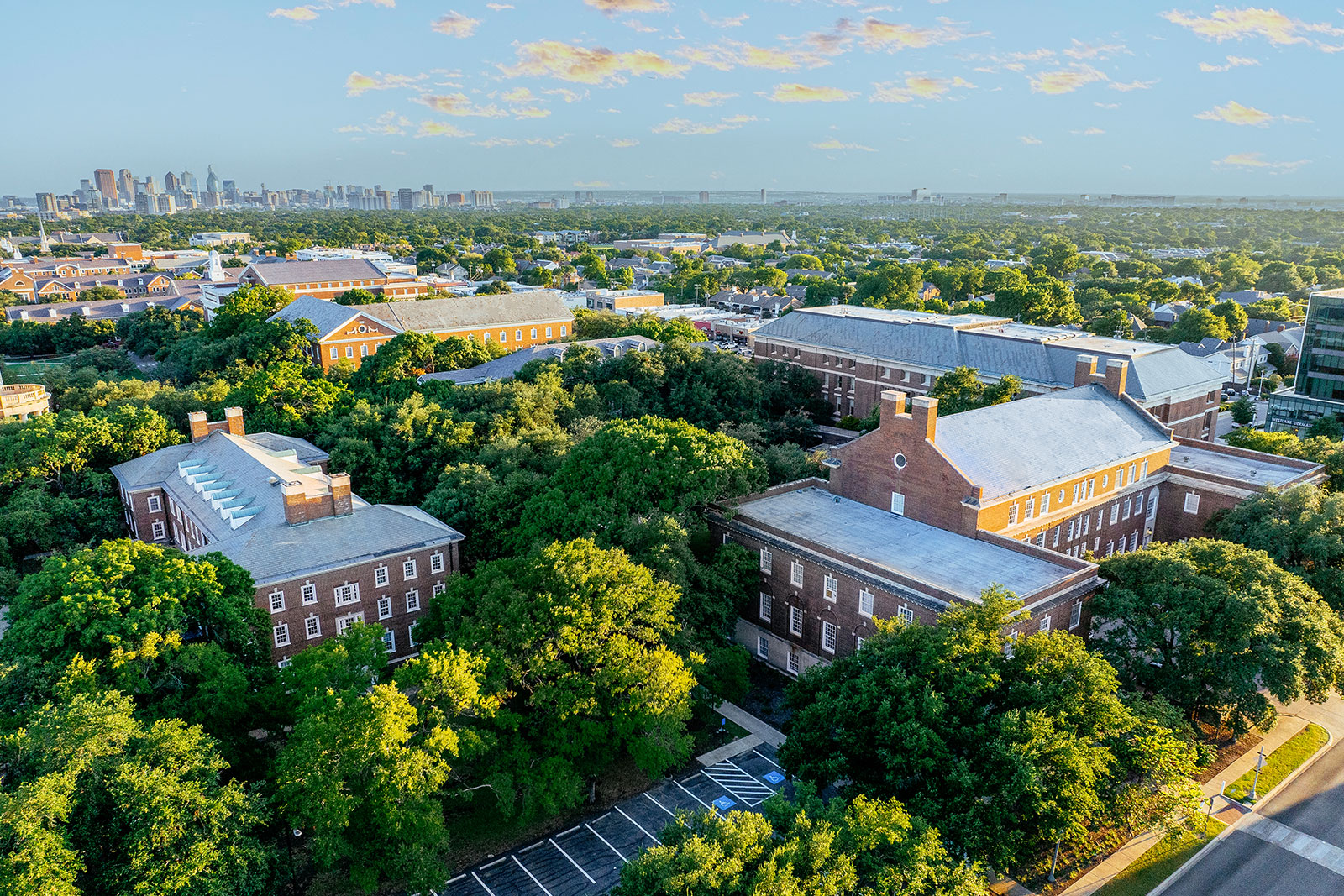 An aerial view of the SMU Dedman School of Law Quadrangle buildings with the Dallas skyline in the distance.