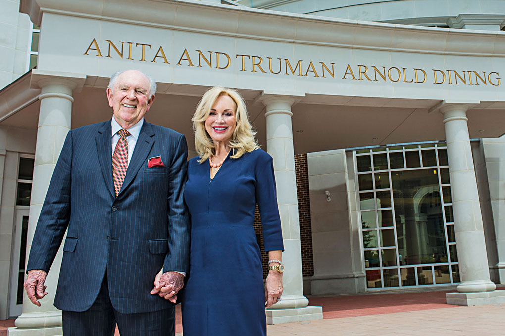 Anita Ray Arnold and Truman Arnold stand in front of the Anita and Truman Arnold Dining Commons at SMU
