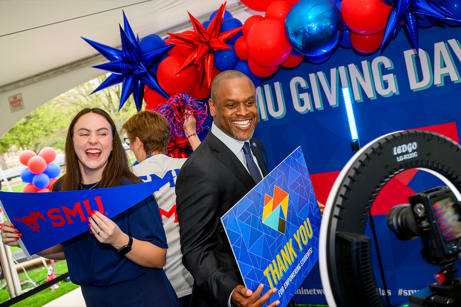 Dr. K.C. Mmeje, senior vice president for Student Affairs at SMU hold an SMU Giving Day sign
