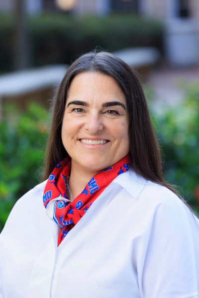 Dean Jeffcoat wearing a white shirt and SMU scarf smiling at the camera