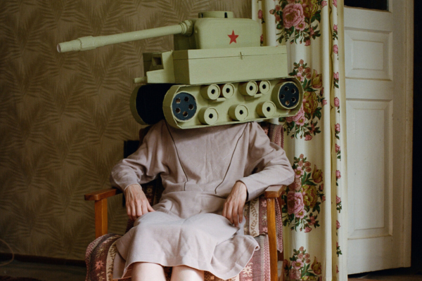 cover art of a woman sitting in a chair with a tank on her head