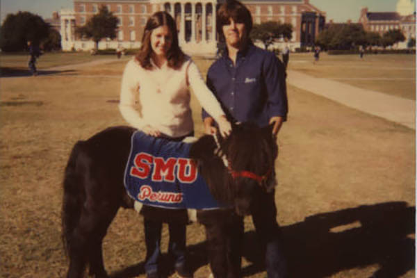 three women looking at smu yearbook together