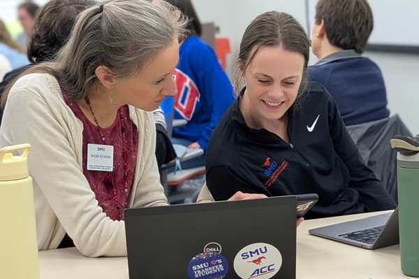 A librarian helping a woman looking at a laptop