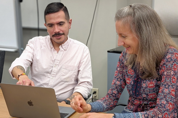 two librarians looking at a laptop