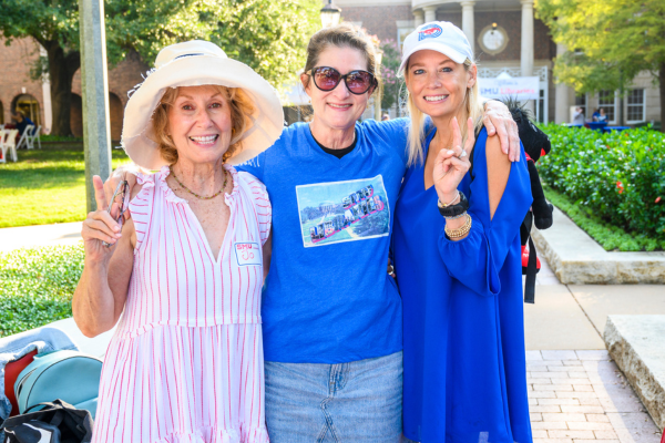 Three smiling Friends board members pose in front of Fondren Library