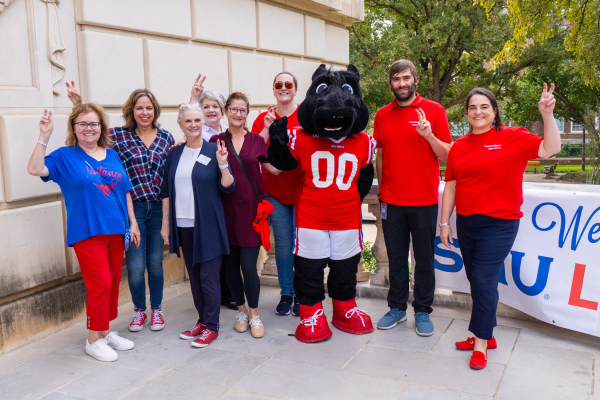 Peruna, library staff, and Friends pose outside the library