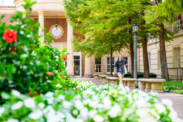 a student walking in front of Fondren Library