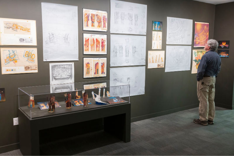 A man looks at drawings on the wall