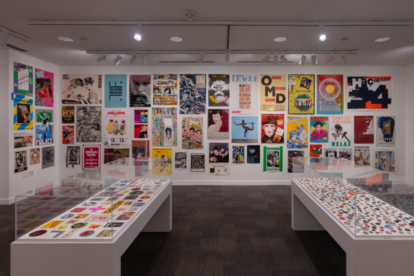 Colorful music posters on the walls and band pins in glass cases in the Hawn gallery