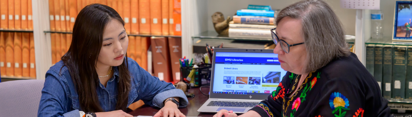 A librarian helps a student with research