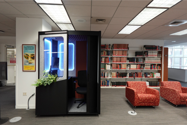 a small, one-person study space with a window and a door