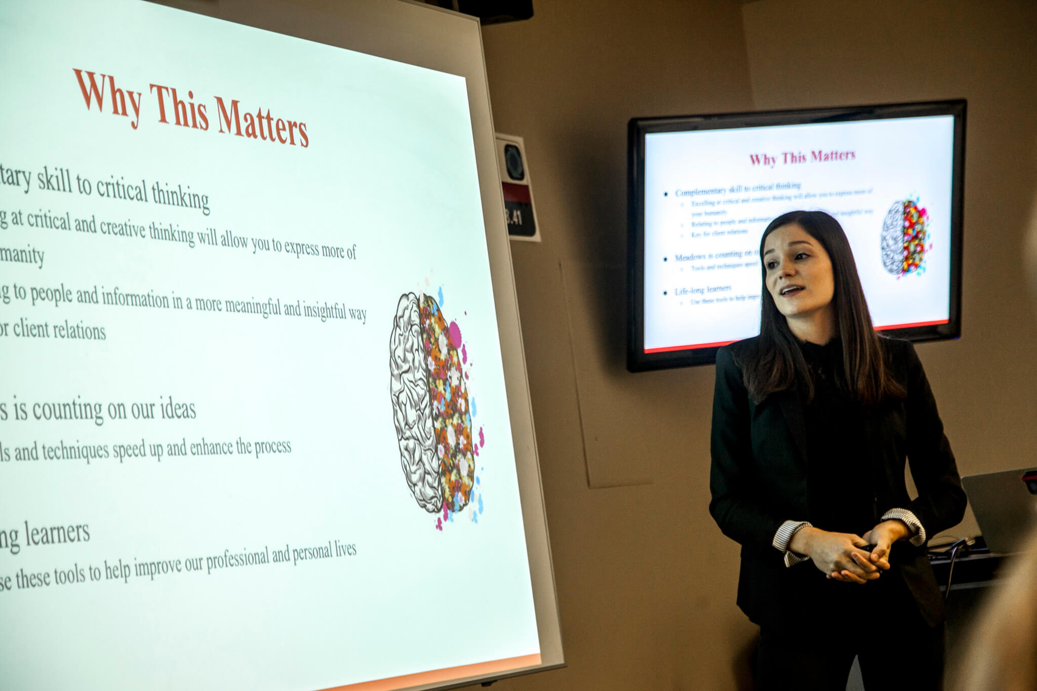 Professor speaking in front of a presentation