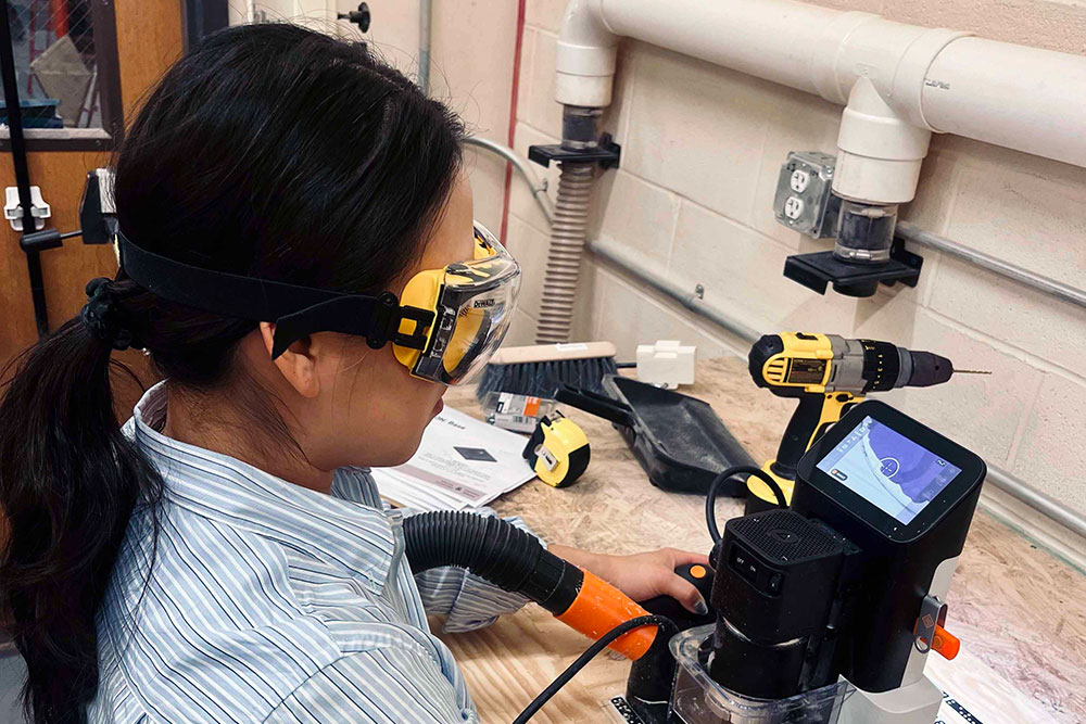 female student works with hi-tech microscope
