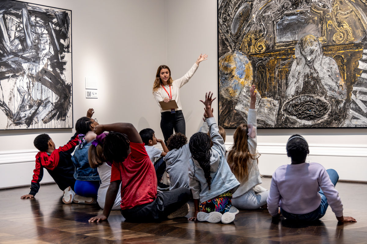 An art history student educates a group of fourth graders on the artwork in the Meadows Museum.