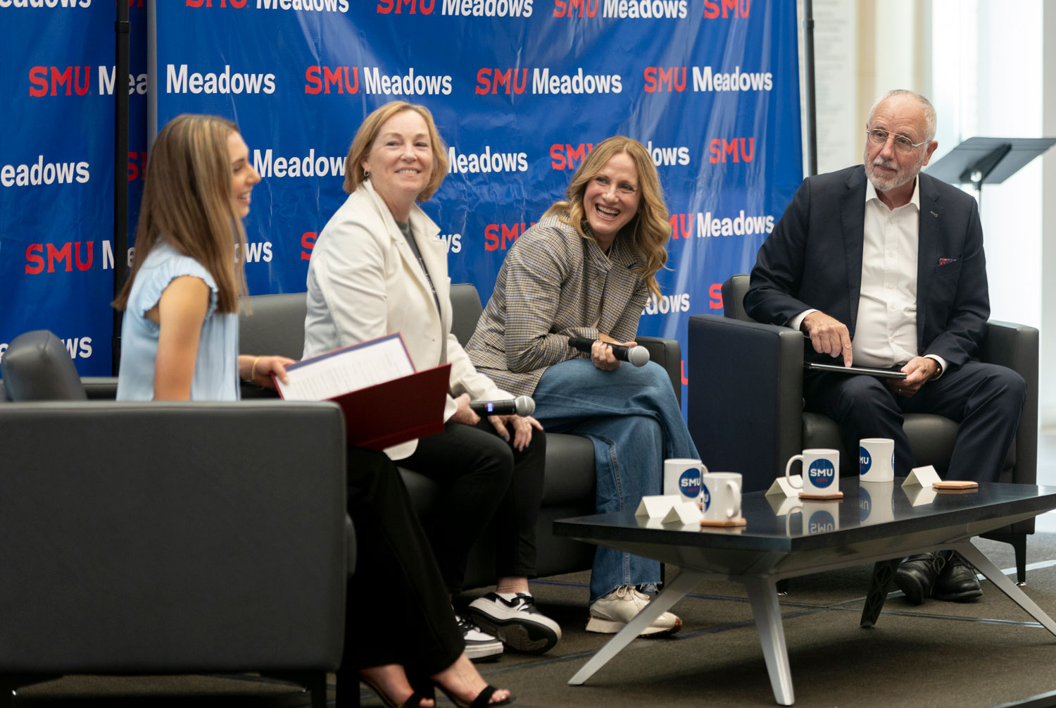 A student, two executive board members, and the Meadows dean on stage hosting a panel