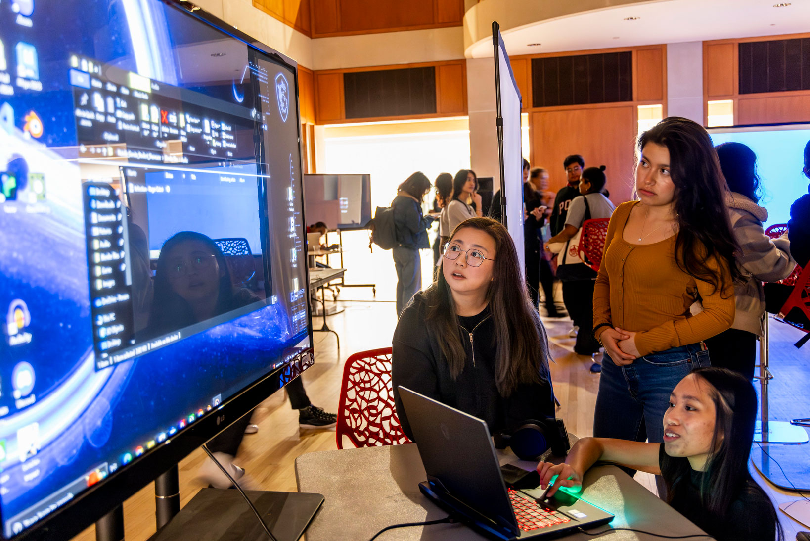 Creative Computation students look at a tech installation on screen at the C3 Spring Showcase.