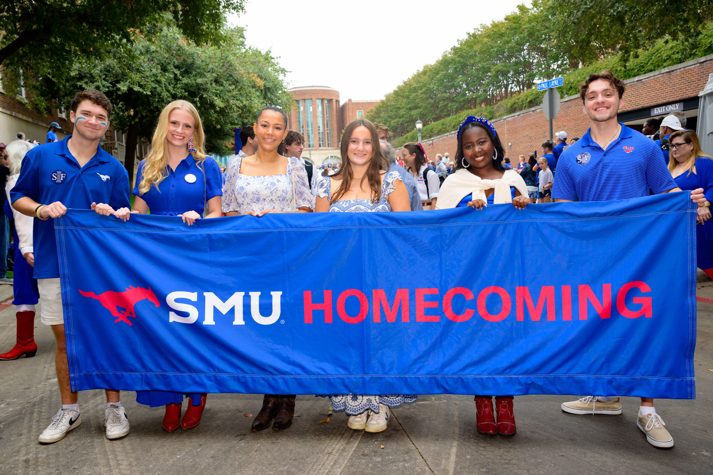 students walk with a large homecoming banner