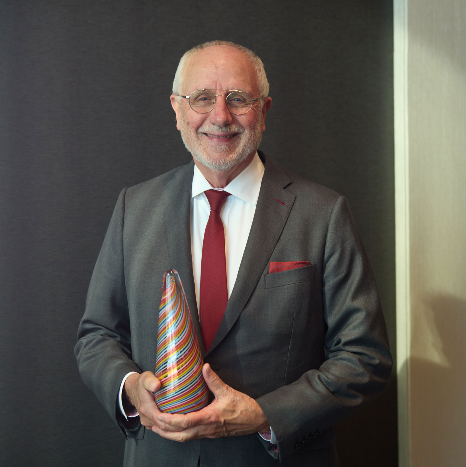 Dean Sam Holland poses holding his Obelisk Award