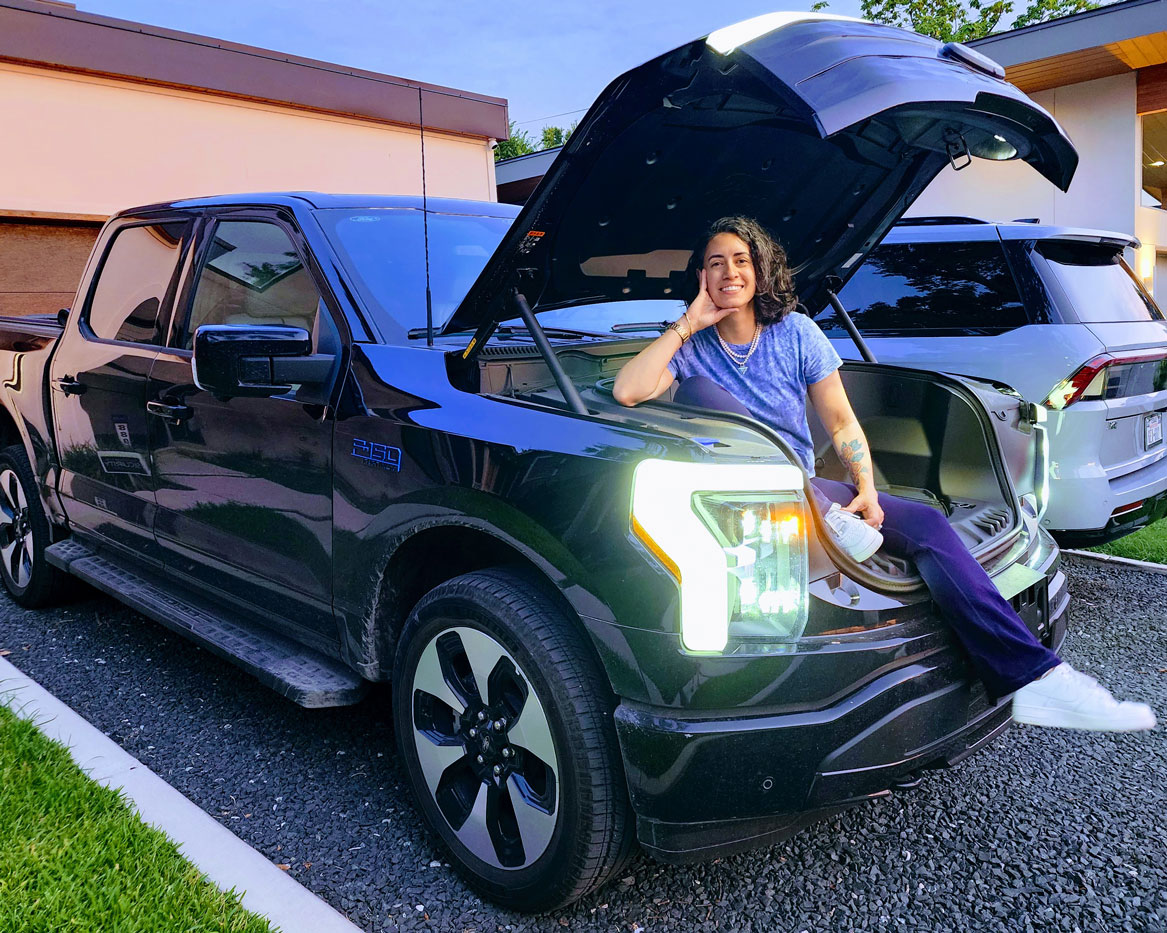 MADI alum Ariel Martin poses in the trunk of a Ford vehicle.