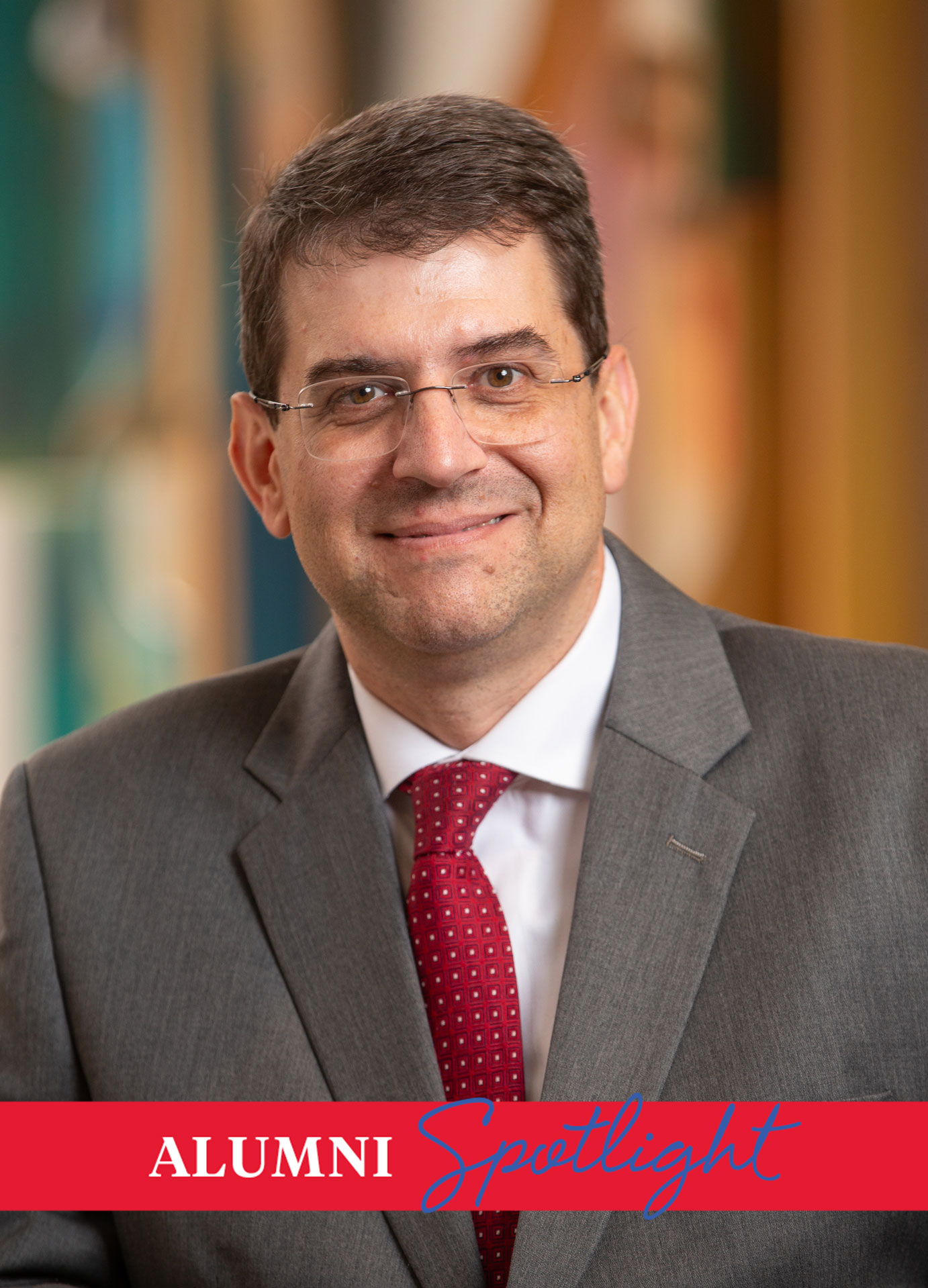 Headshot of Meadows alum Peter Jutras in a suit with a red tie.
